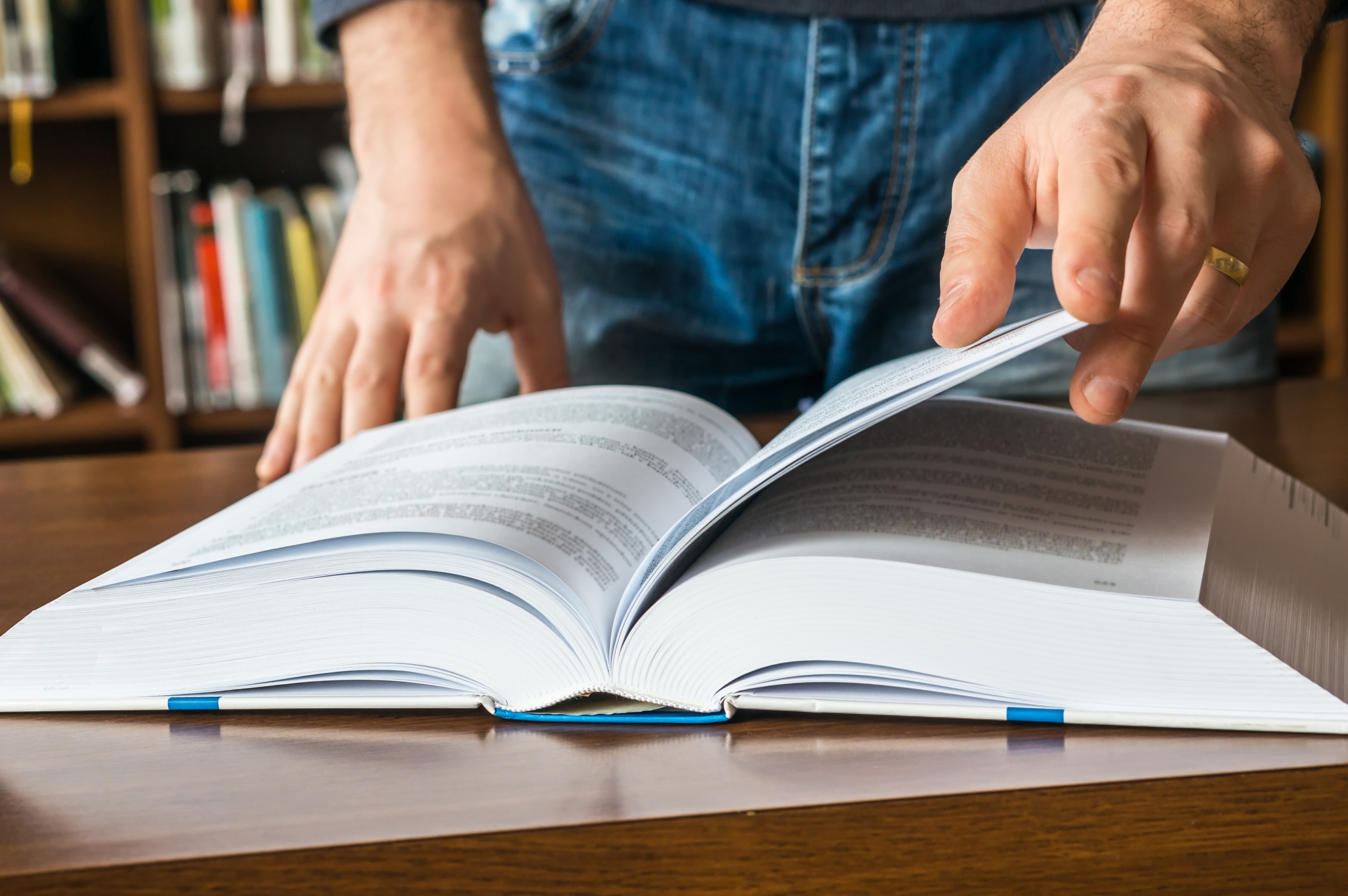 Gros plan des mains d’une personne feuilletant un livre