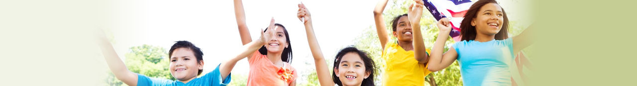 Des enfants debout dehors en agitant des drapeaux