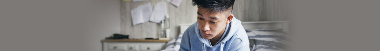 Student in bedroom writing